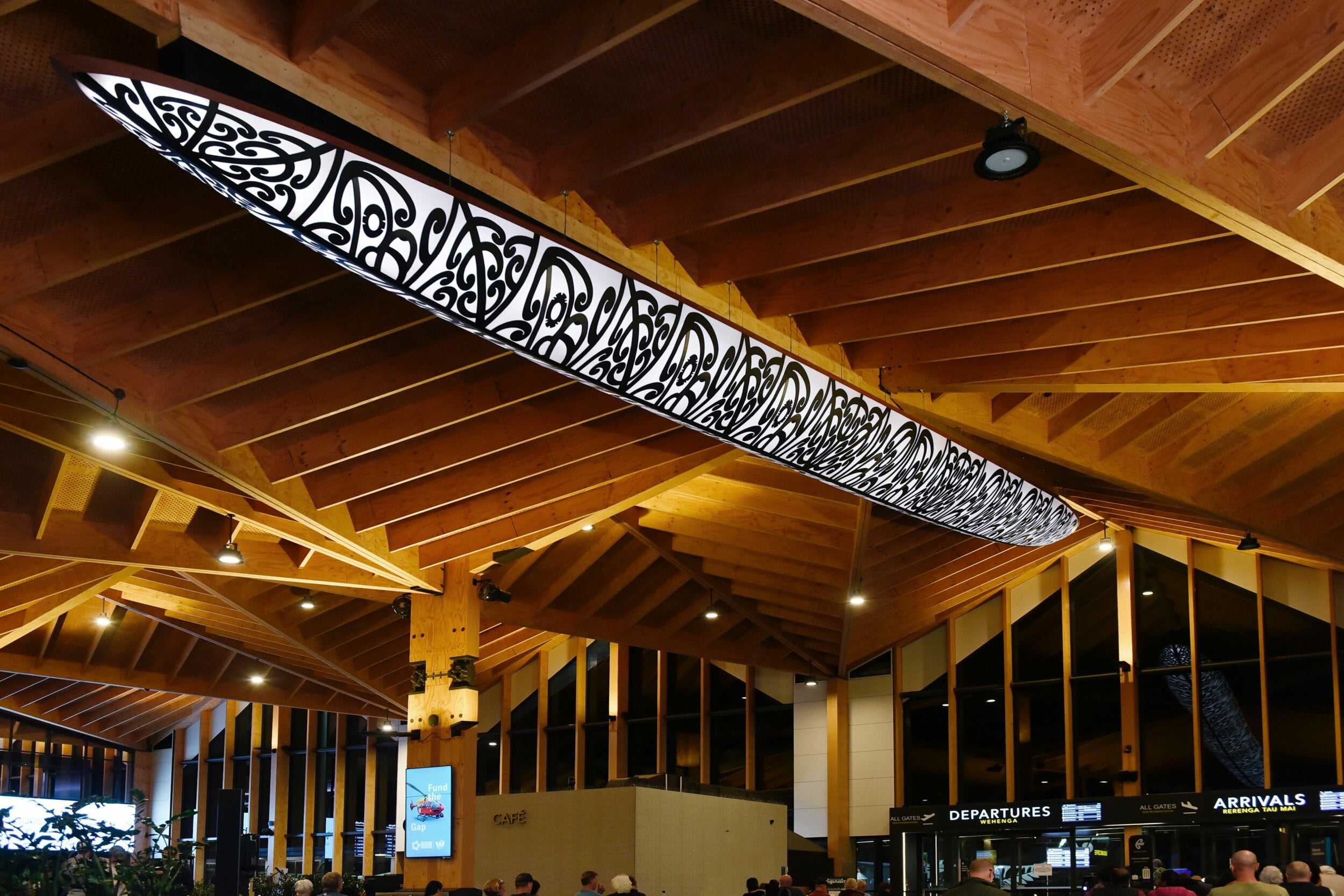 Waka Aorere Ararau illuminated white against the wooden terminal ceiling