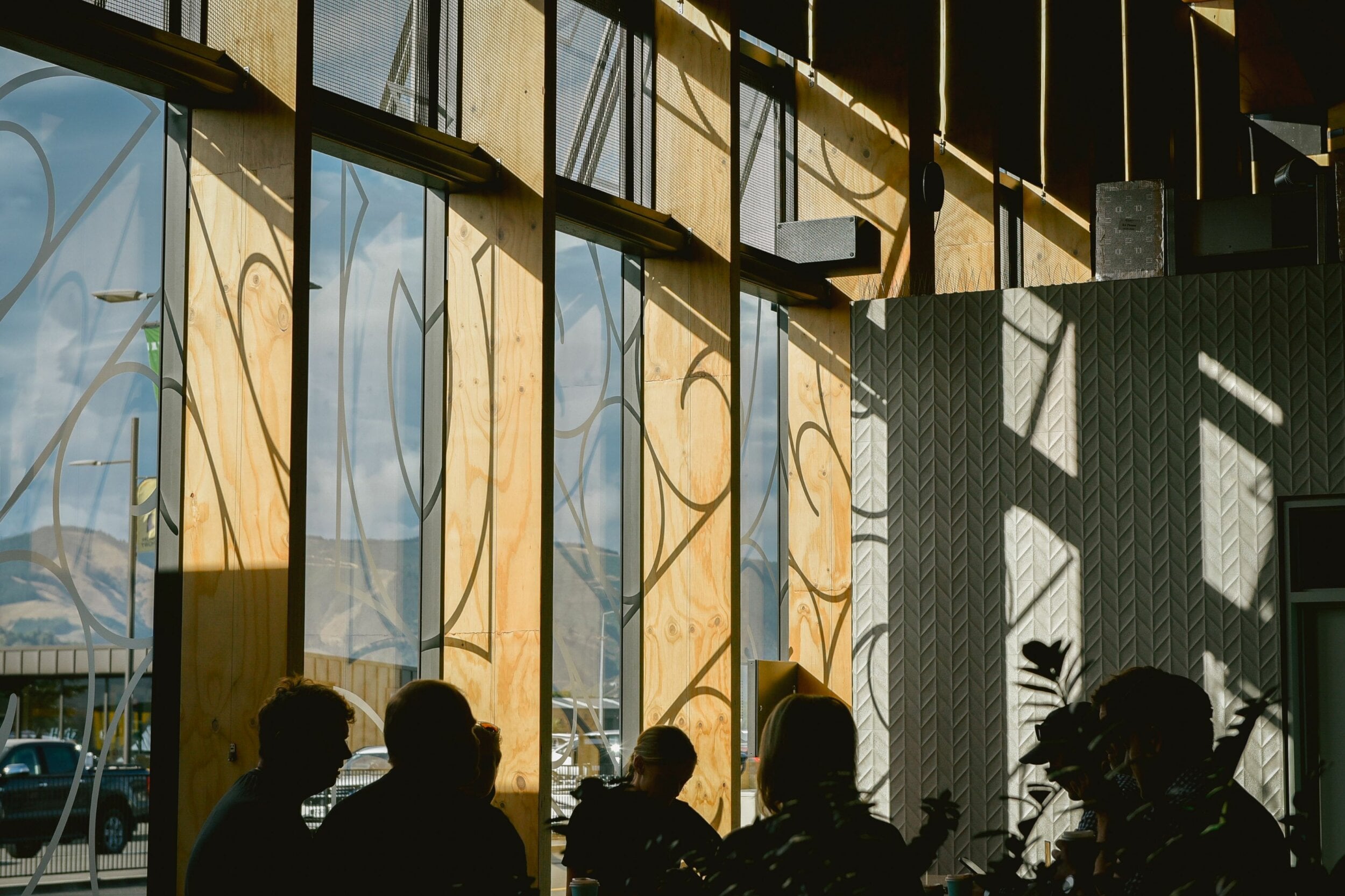 Kōwhaiwhai patterning on the terminal windows is cast as shadows on the wooden frames and nearby walls.