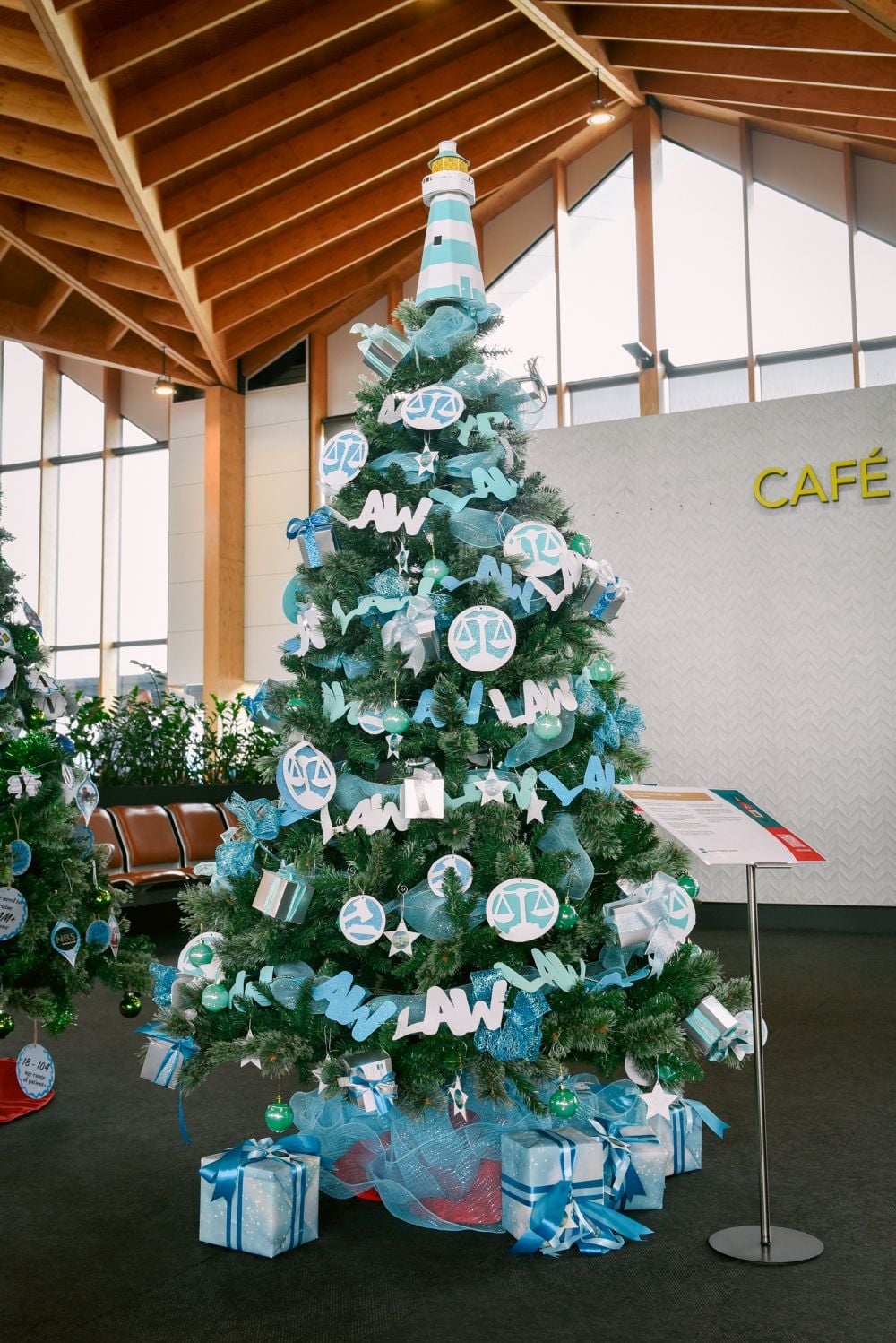 Christmas tree in the airport terminal with blue and white decorations and gifts underneath. Sponsored by Hamish Fletcher Lawyers for the 2025 Nelson Aieport